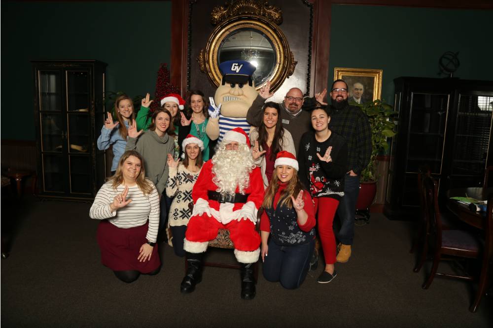 Young Alumni Council members posing with Santa and Louie the Laker